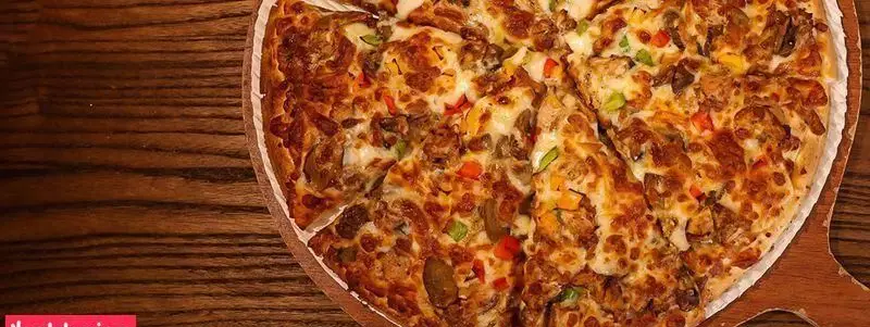 پیتزا لذیذ و داغ فست فود چیتر چیکن، با پنیر فراوان، قارچ تازه، تکه‌های مرغ و فلفل دلمه‌ای رنگی، آماده سفارش و ارسال.