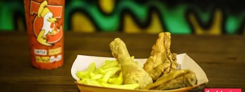 سفارش لذیذ فست فود چیتر چیکن: مرغ سوخاری کریسپی به همراه سیب زمینی سرخ کرده و نوشیدنی با لوگوی جوجه. تجربه غذایی عالی.