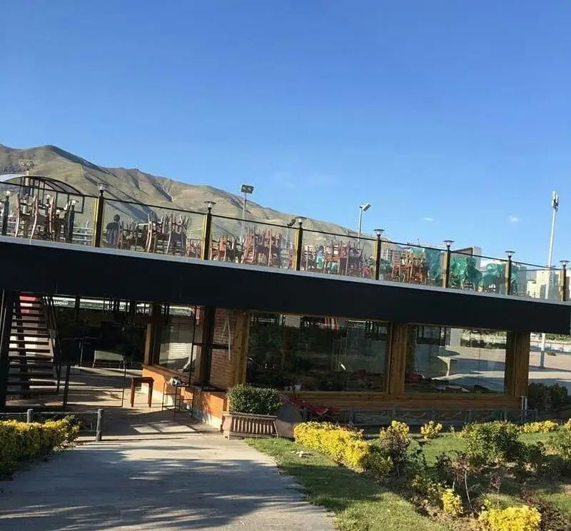 کافه رستوران استیج با دو طبقه، تراس بزرگ روباز مجهز به میز و صندلی، محیطی دلنشین با ویوی کوهستان برای تجربه‌ای خاص.