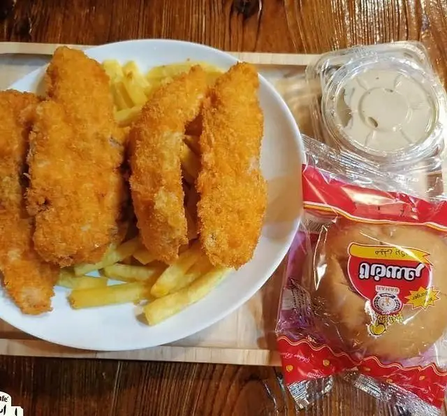 مرغ سوخاری و سیب‌زمینی سرخ کرده خوشمزه در کافه رستوران استیج، همراه با سس و نان برگر تازه. تجربه‌ای لذت‌بخش از فست فود.