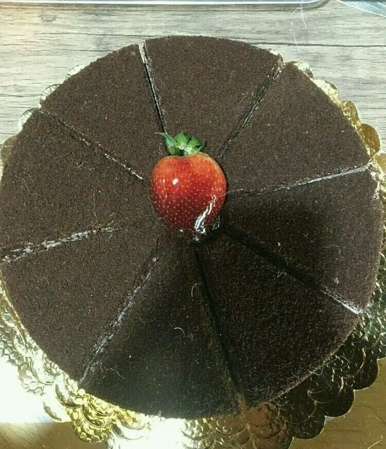 کیک شکلاتی مخملی برش خورده با تزیین توت فرنگی، بهترین دسر و شیرینی کافه رستوران استیج برای تجربه ای شیرین و به یادماندنی.