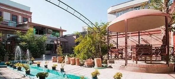 رستوران سنتی باغ شازده: نمای زیبا از فضای باز با آب‌نما، فواره‌ها، آلاچیق چوبی و محیط سرسبز، مناسب برای لحظاتی دلپذیر.