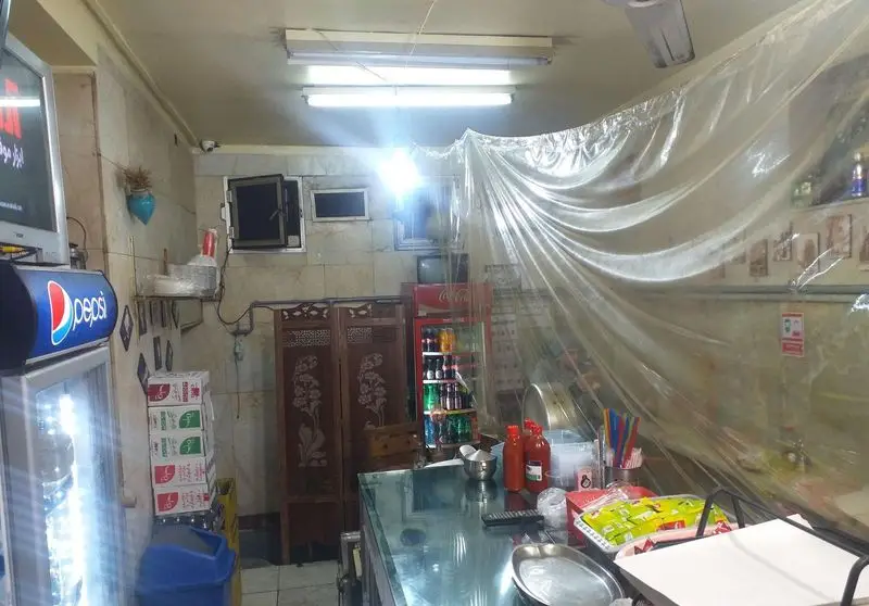 تصویری از فضای داخلی ساندویچ فروشی آذر، با پیشخوان شیشه‌ای، یخچال‌های پپسی و کوکا، محیطی منظم و آماده ارائه خدمات فست فود.