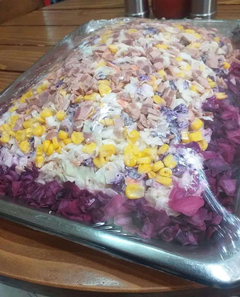 ساندویچ آذر: سالاد کلم مجلسی با لایه‌های ذرت، کالباس و کلم بنفش. انتخابی عالی برای پذیرایی در مهمانی‌ها از ساندویچ آذر.