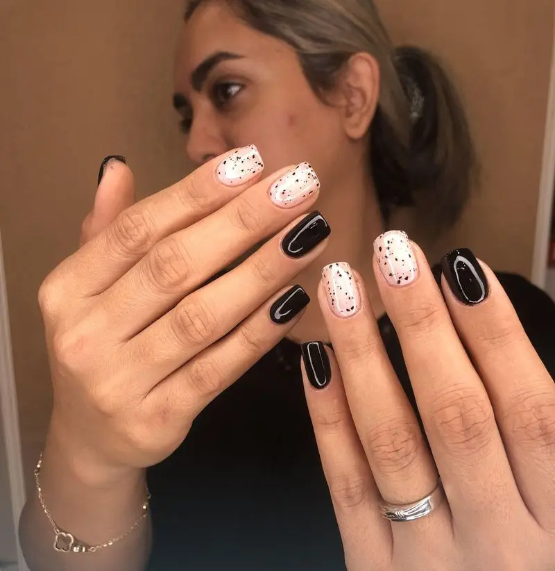 طراحی ناخن اسپرت و شیک با ترکیب لاک ژل مشکی براق و لاک صورتی ملایم با طرح خالخالی ریز مشکی شبیه تخم بلدرچین