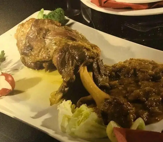 ران گوسفند لذیذ و مجلسی رستوران هفت خوان، سرو شده با سس مخصوص و تزئینات تازه. یک غذای ایرانی عالی برای میهمانی‌ها.