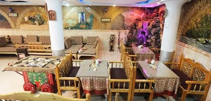 محیط داخلی زیبای رستوران و سفره خانه مجنون، با طراحی سنتی و آبنمای دلنشین، فضایی آرام برای صرف غذا و قلیان.