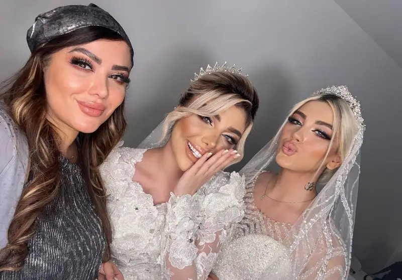عکس سلفی دو عروس زیبا با تاج و تور درخشان در کنار میکاپ آرتیست با آرایش غلیظ و حرفهای در سالن زیبایی و آرایشگاه زنانه