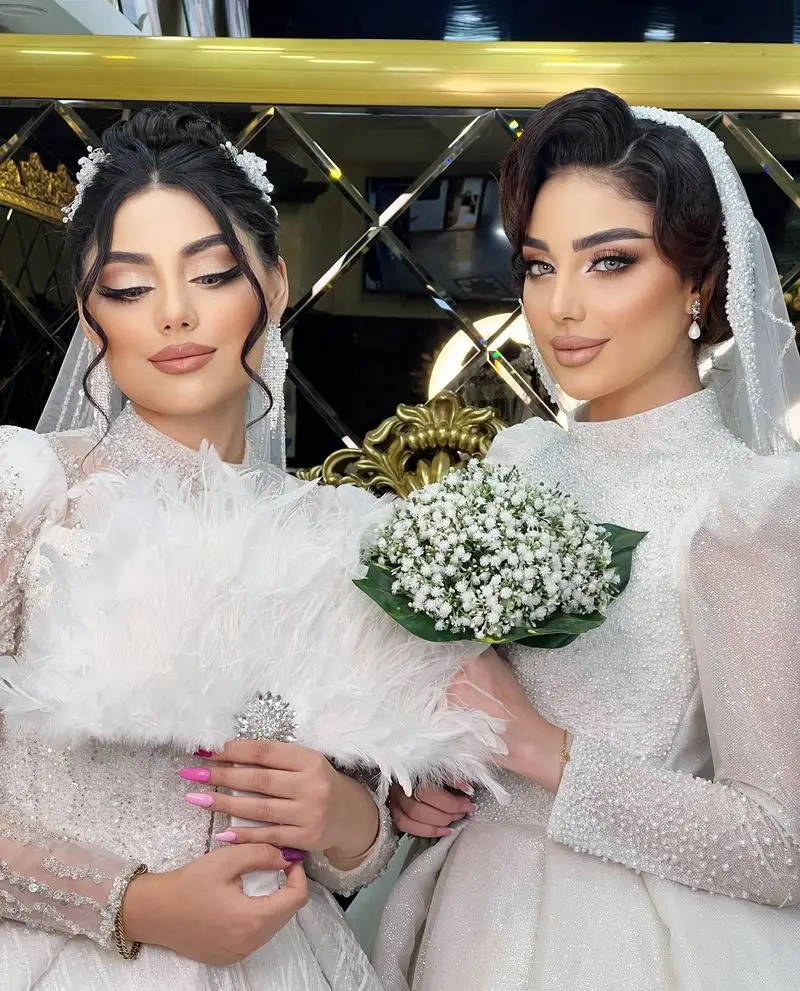 سالن زیبایی نیلوفرآبی: دو عروس خیرهکننده با میکاپ و شینیون مدرن، نشاندهنده تخصص ما در خدمات عروس و آرایشگاه زنانه.