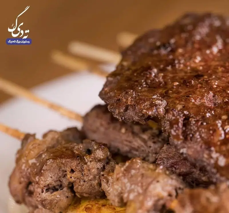 عکس نزدیک از سیخ‌های کباب جگر و گوشت تازه و آبدار در رستوران بزرگ ته دیگ، با رنگ قهوه‌ای طلایی و طعمی بی‌نظیر.