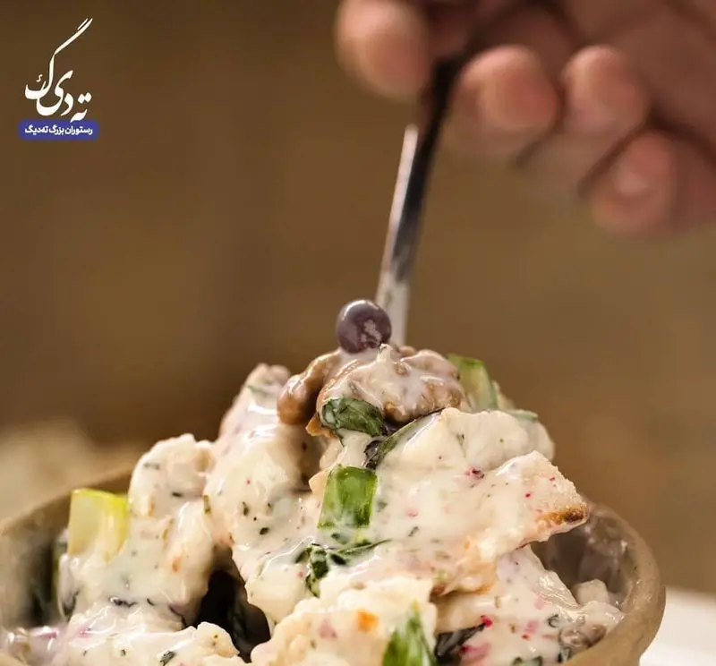 سالاد مرغ و گردو کرمی، یک پیش غذای خوشمزه و اشتهاآور از رستوران بزرگ ته دیگ، آماده سرو با سس مخصوص و تزئین لوکس.