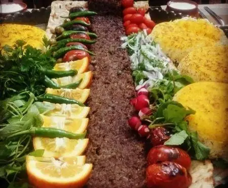 سینی بزرگ و رنگارنگ غذای ایرانی تهیه غذا و فست فود به پخت با کباب، برنج زعفرانی، سبزیجات تازه، فلفل و گوجه کبابی. مناسب مهمانی.