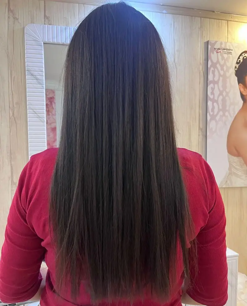 خدمات کراتینه و صافی موی بلند و قهوهای تیره زنانه با ظاهری درخشان و ابریشمی در سالن زیبایی پر بیوتی از نمای پشت سر