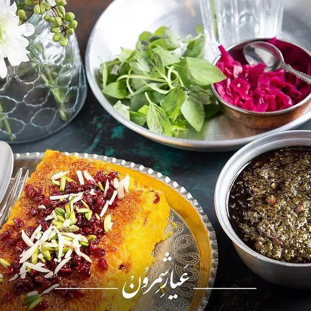 ته چین مجلسی زرشک و خلال پسته رستوران عیار شمرون، همراه با قورمه سبزی، سبزی تازه و ترشی خوشمزه؛ تجربه‌ای بی‌نظیر از غذای اصیل ایرانی.