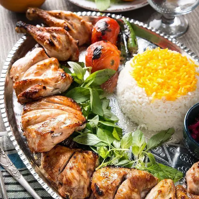 غذای خوشمزه و سنتی ایرانی شامل جوجه کباب، چلو زعفرانی و سبزی تازه در رستوران عیار شمرون، بهترین انتخاب برای ناهار و شام.