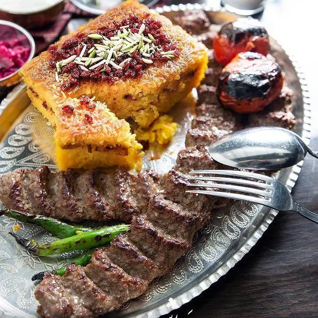 کباب کوبیده و ته چین زعفرانی با زرشک و خلال پسته، غذای لذیذ و سنتی رستوران عیار شمرون، انتخابی عالی برای ناهار و شام.