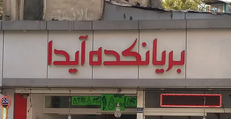 تابلوی مغازه بریانکده آیدا با نام کسب و کار به رنگ قرمز و برجسته، نشان دهنده رستوران و سرو غذای محبوب بریانی