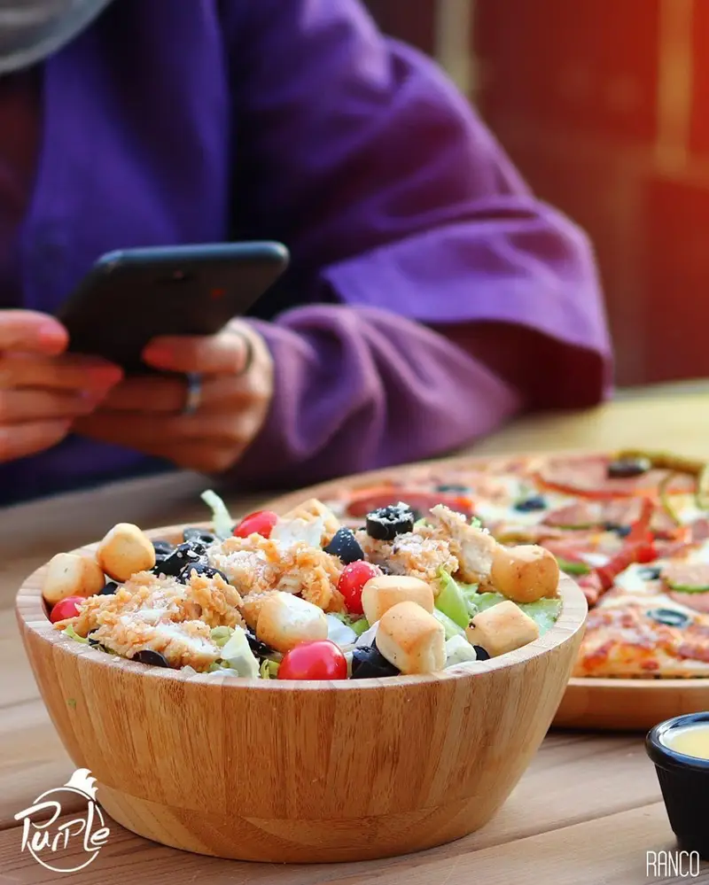 سالاد مرغ سوخاری پرپل با گوجه، زیتون و نان سیر. تجربه لذیذترین طعم ها در رستوران پرپل سوخاری در کنار پیتزای داغ.