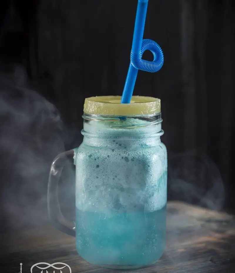 نوشیدنی آبی خنک و مخصوص کافه عربی کازابلانکا، با حباب و دود جذاب، ایده‌آل برای روزهای گرم تابستان و تجربه طعم‌های جدید.