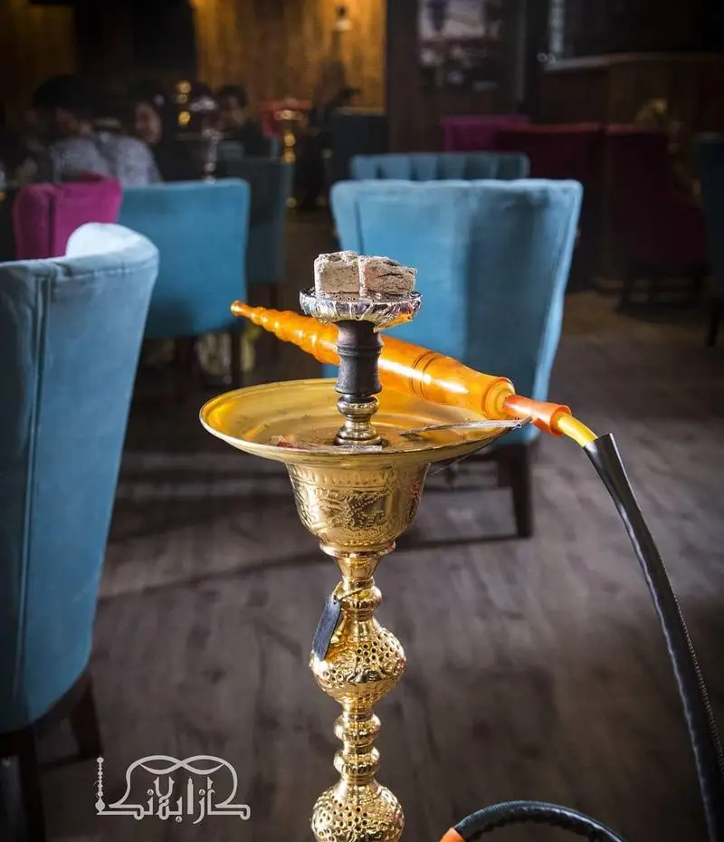 تصویری جذاب از قلیان طلایی سنتی در کافه عربی کازابلانکا، مکانی دلپذیر برای لذت بردن از فضای آرام و نوشیدنی‌های خاص.
