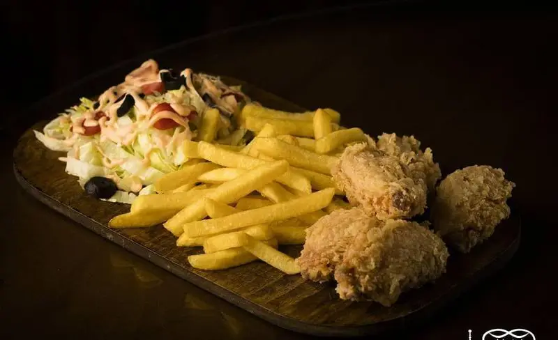 بشقاب غذای کامل کافه عربی کازابلانکا: مرغ سوخاری ترد، سیب زمینی سرخ کرده طلایی و سالاد سبزیجات تازه با سس مخصوص