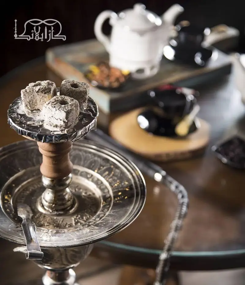 فضای دلنشین کافه عربی کازابلانکا با قلیان زغالی آماده، چای گرم و ظروف سنتی. تجربه‌ای دنج از شیشا و نوشیدنی.