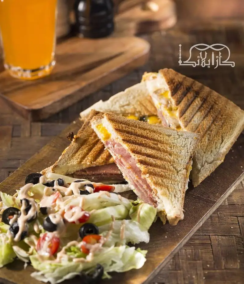 ساندویچ تست گوشت و پنیر خوشمزه کافه عربی کازابلانکا با سالاد تازه و آب پرتقال، انتخابی عالی برای صبحانه و ناهار.