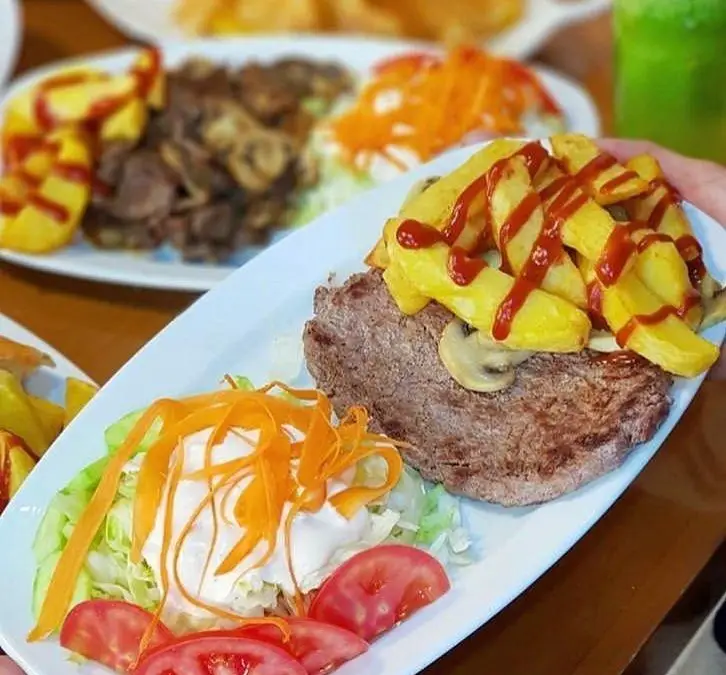 استیک بزرگ و آبدار با سیب زمینی سرخ کرده، قارچ، سس کچاپ و سالاد تازه کاهو و هویج در فست فود ترنج شعبه ۳ برای تجربه یک غذای خوشمزه.