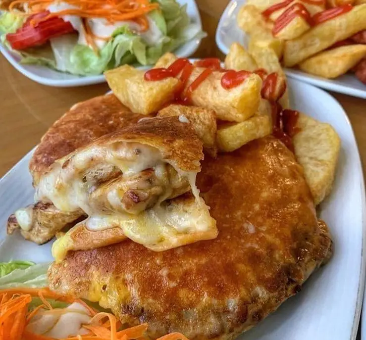 کالزون مرغ و پنیر ذوب شده فست فود ترنج شعبه ۳، با سیب زمینی سرخ کرده سس کچاپ و سالاد تازه، یک وعده غذایی دلچسب.