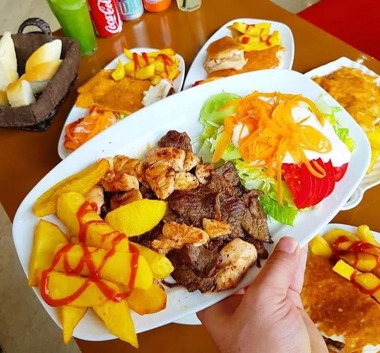 غذای کامل از فست فود ترنج شعبه ۳: بشقاب میکس گریل شامل فیله مرغ و گوشت، سیب‌زمینی سرخ کرده با سس کچاپ، سالاد تازه و نان کنار نوشیدنی‌ها.