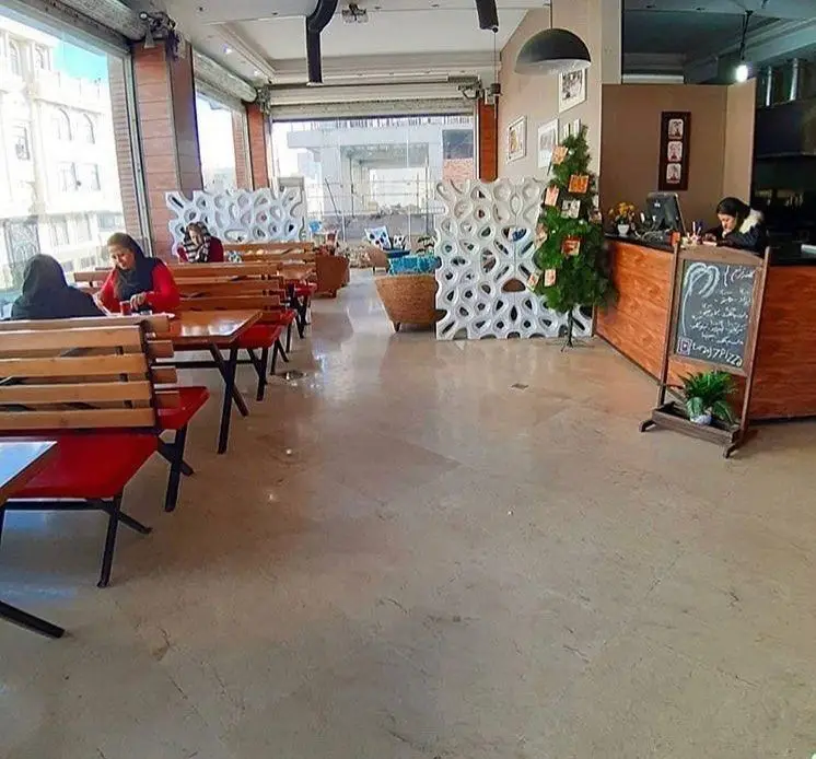 نمایی از داخل فست فود ترنج شعبه ۳ با مشتریان، میز و صندلی‌های چوبی، دکوراسیون مدرن و فضایی دلنشین برای سرو غذا و نوشیدنی.