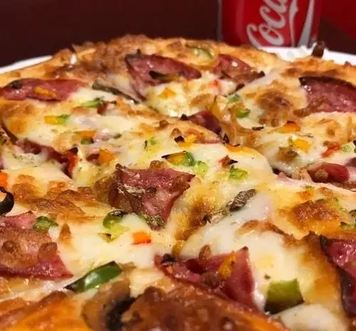 پیتزای خوشمزه فست فود ترنج شعبه ۳ با پپرونی، قارچ، فلفل دلمه ای رنگی و پنیر فراوان، همراه با نوشابه کوکاکولا.