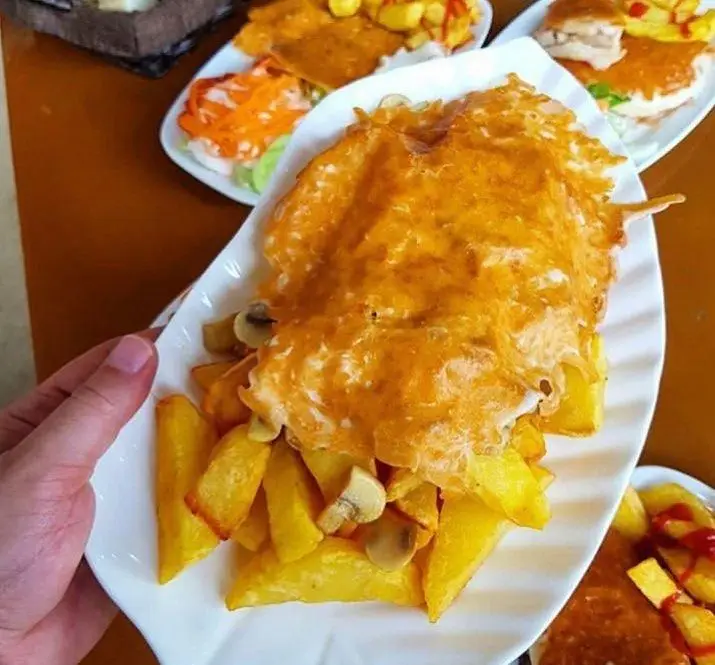 سیب زمینی سرخ کرده طلایی با پنیر ذوب شده و قارچ، غذایی لذیذ از منوی فست فود ترنج شعبه ۳، انتخابی ایده‌آل برای یک وعده خوشمزه.