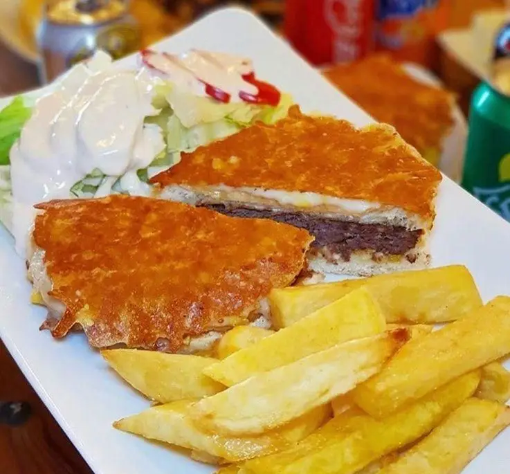 غذای لذیذ فست فود ترنج شعبه ۳: ساندویچ گریل با پنیر سوخاری و برگر گوشت، به همراه سیب زمینی سرخ کرده و سالاد فصل با سس.