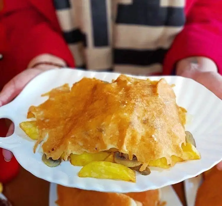 یک بشقاب غذای خوشمزه از فست فود ترنج شعبه ۳ شامل سیب زمینی، قارچ و روکش پنیر طلایی. تجربه‌ای لذیذ و دلپذیر.