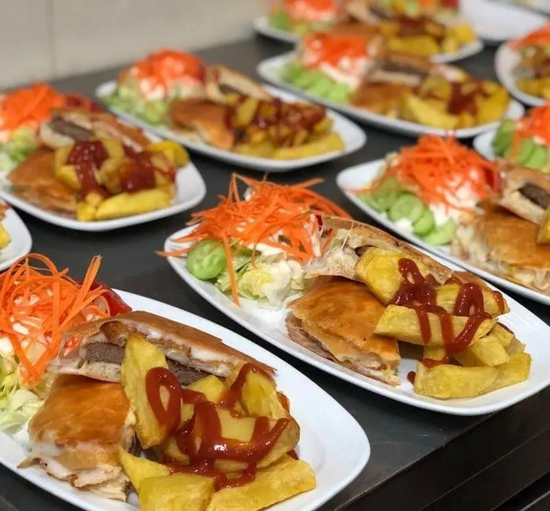 فست فود ترنج شعبه ۳: چندین بشقاب ساندویچ برشته با سیب‌زمینی سرخ کرده و سس کچاپ، همراه سالاد تازه و هویج. غذای آماده لذیذ