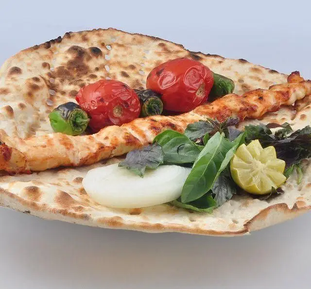 یک پرس کامل جوجه کباب ویژه کباب سرای برگ سبز روی نان سنگک سنتی با مخلفات گوجه، فلفل، پیاز و سبزی معطر.