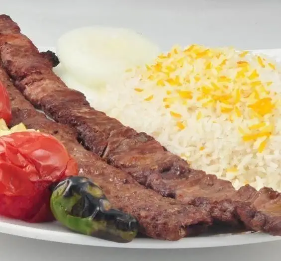 چلو کباب کوبیده لذیذ برگ سبز با برنج زعفرانی، گوجه، فلفل کبابی و پیاز. بهترین کباب کوبیده در کباب سرای برگ سبز.