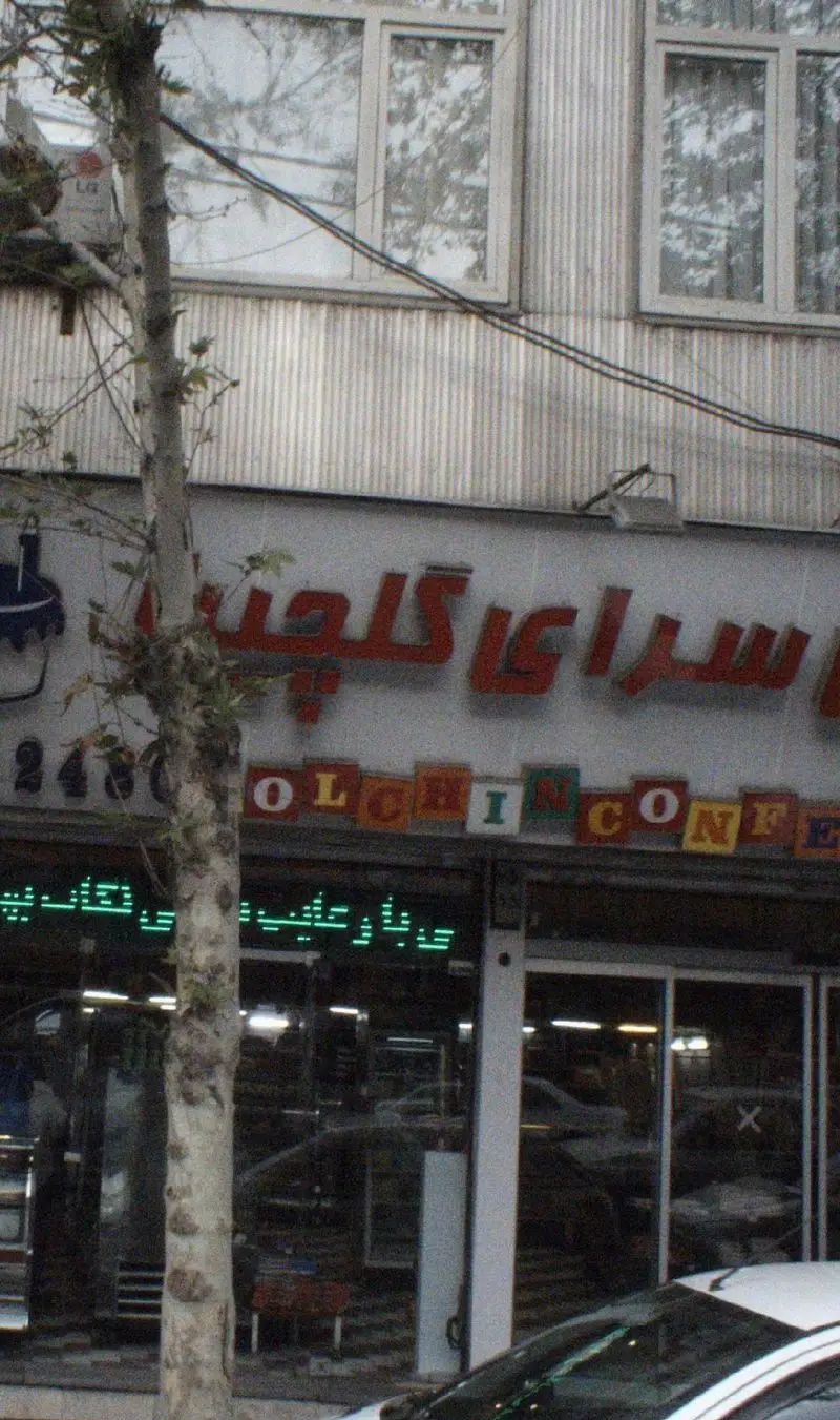 نمای بیرونی شیرینی سرای گلچین، یک قنادی و شیرینی فروشی شناخته شده در شهر با تابلوی فارسی و انگلیسی، آماده پذیرایی از مشتریان.