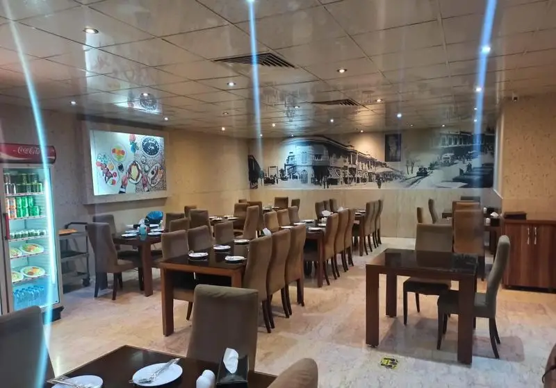 فضای داخلی وسیع و زیبای رستوران ایرانی اصل جوان، با میز و صندلی‌های شیک و دکوراسیون دلنشین، مکانی عالی برای لذت بردن از غذای ایرانی اصیل.