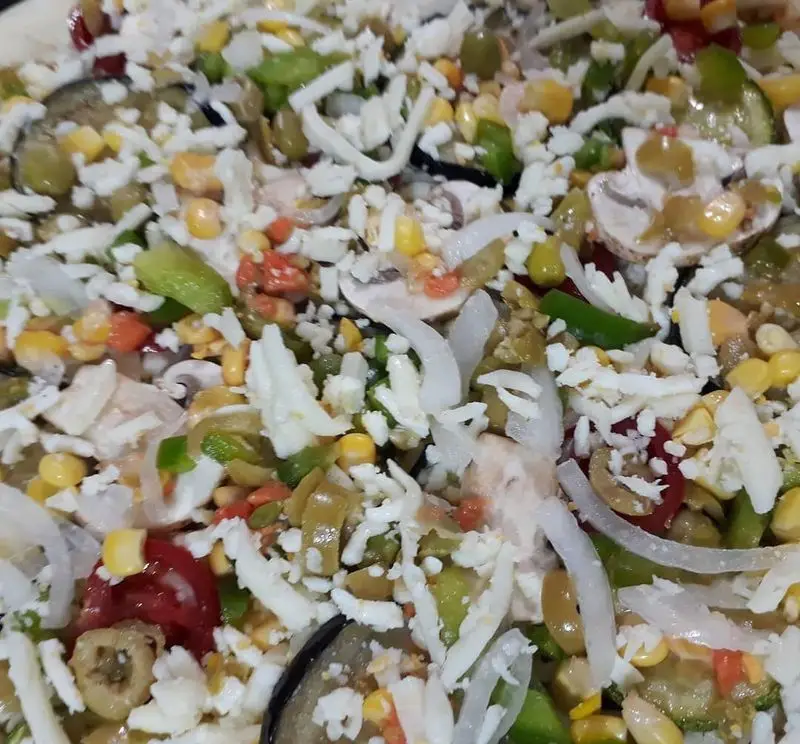 نمای نزدیک از پیتزا سبزیجات پر ملات علی بابا با پنیر فراوان، قارچ، ذرت شیرین، زیتون، فلفل دلمه‌ای و پیاز تازه