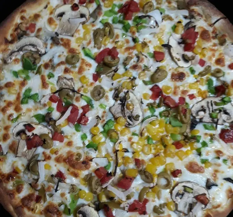 پیتزای تازه و لذیذ پیتزا و کباب ترکی علی بابا با ترکیبی رنگارنگ از قارچ، ذرت، فلفل دلمه‌ای، زیتون و پنیر موزارلا.