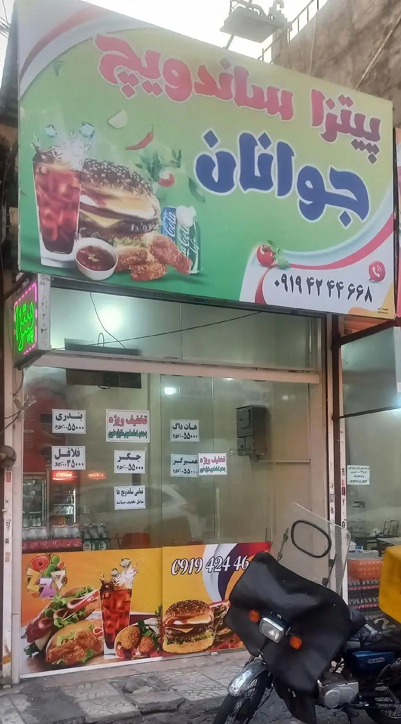 تصویر تابلوی پیتزا ساندویجی جوانان، شامل عکس‌های جذاب پیتزا، همبرگر، ساندویچ، مرغ سوخاری و فالافل با شماره تماس جهت سفارش غذای بیرون‌بر