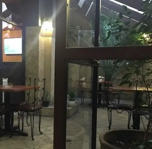 نمایی از فضای داخلی و بیرونی دلنشین کافه رستوران سون استاپ، با دکوراسیون شیک و میز و صندلی‌های راحت، مناسب برای دورهمی.