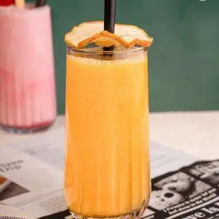 یک لیوان بلند اسموتی پرتقال تازه و جذاب با تزیین پرتقال در کافه رستوران لاماسو، نوشیدنی ایده‌آل و پر ویتامین C.