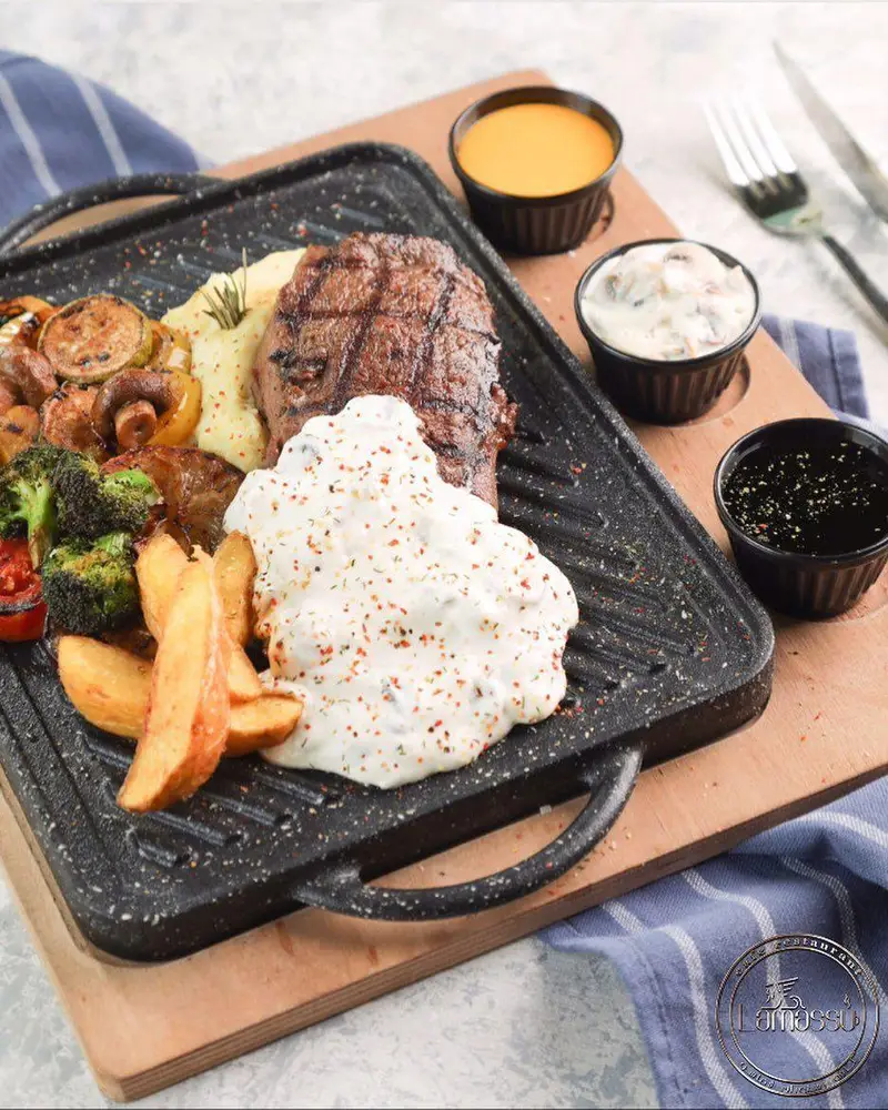 استیک گریل شده آبدار با پوره سیب‌زمینی، سیب‌زمینی خلالی، سبزیجات تازه و سس‌های متنوع در کافه رستوران لاماسو.