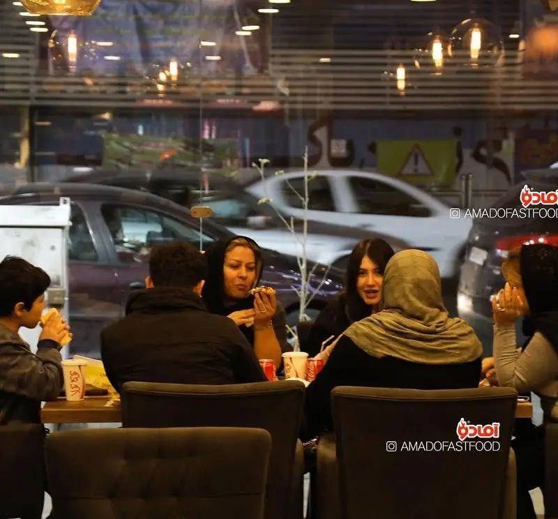 مشتریان در حال لذت بردن از غذاهای خوشمزه در فست فود پیلوت. فضایی دلنشین برای دورهمی‌های دوستانه و خانوادگی با فست فودهای باکیفیت.