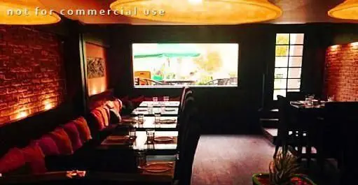 فضای داخلی رستوران ایتالیایی هیت، دنج و گرم با دیوارهای آجری و نورپردازی خاص. میزهای آماده پذیرایی برای یک تجربه شام دلنشین.