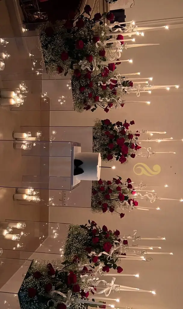 چیدمان رمانتیک و مجلل مراسم با گل‌آرایی رز قرمز، شمع‌های بلند و میزهای شیک از ظروف کرایه بلادی. بهترین انتخاب برای اجاره ظروف جشن‌ها و تشریفات.