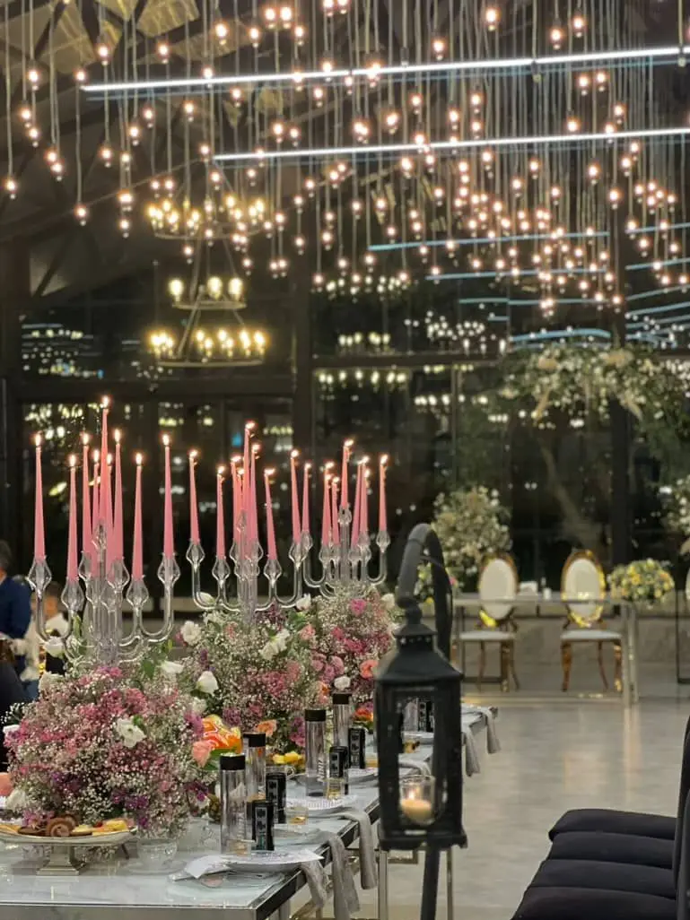 تصویری از میز آرایی شیک و دکوراسیون مجلل مراسم با شمع، گل و ظروف پذیرایی، خدمات ظروف کرایه و تجهیزات مجالس بلادی.